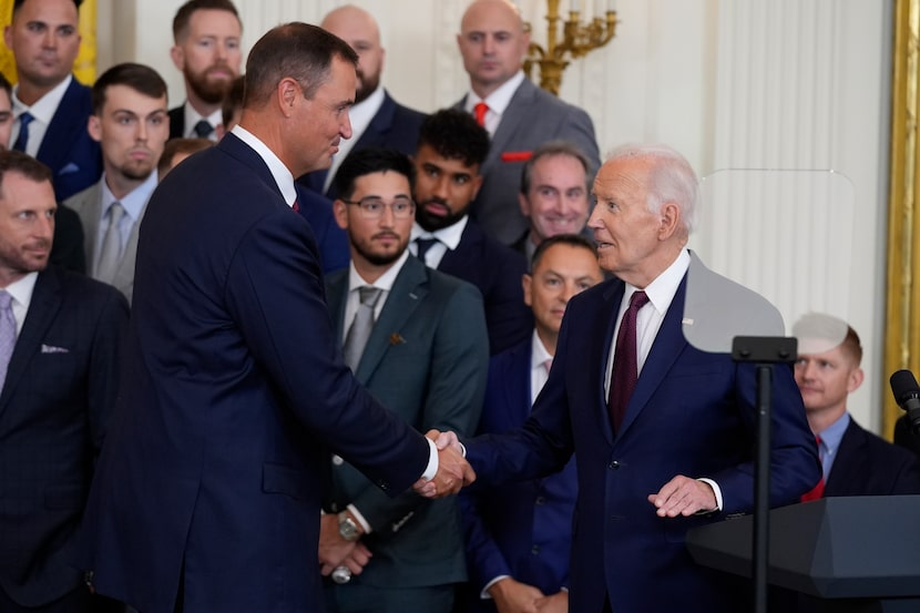 President Joe Biden, right, shakes the hand of Texas Rangers general manager Chris Young,...