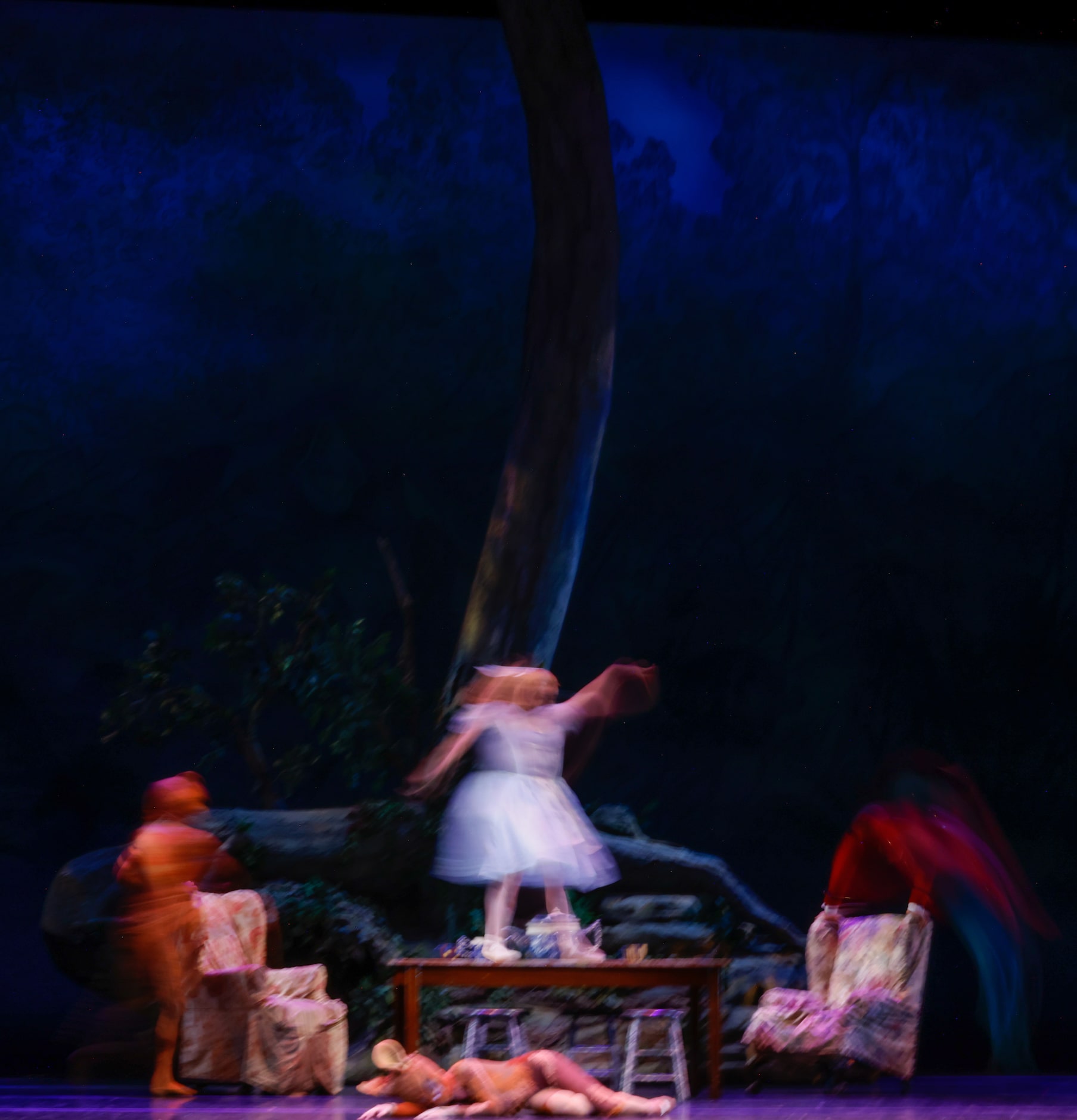 Alexandra F. Light (center) follows the Mad Hatter across the stage during the tea party...