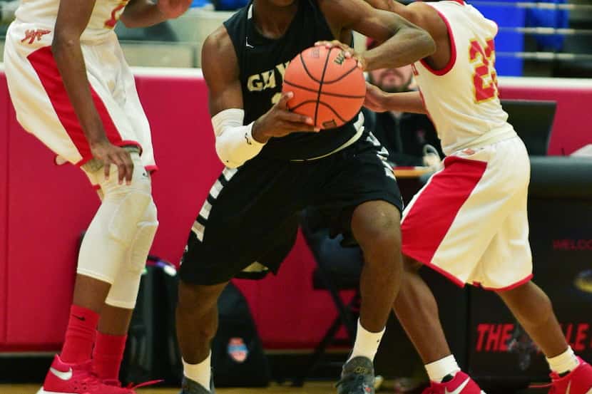 Guyer freshman guard Devion Harmon (11) get a hand to the face while covered by South Grand...