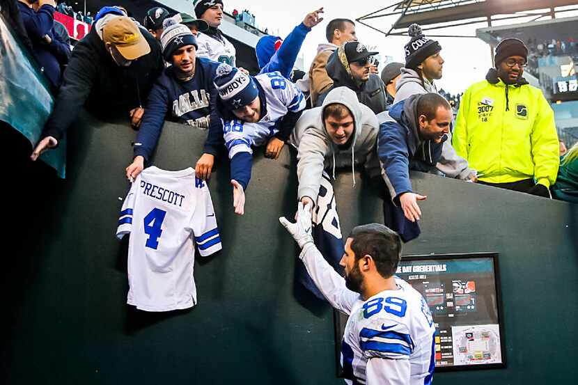 Dallas Cowboys tight end Gavin Escobar high fives fans after an NFL football game against...