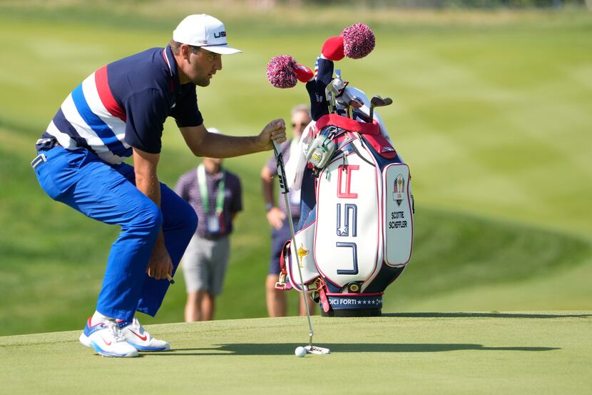 United States' Scottie Scheffler look at his putt on the 3rd green during a practice round...