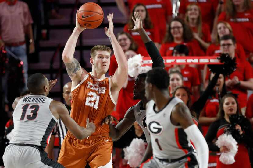 Texas forward Dylan Osetkowski (21) looks to pass the ball while being defended by Georgia...
