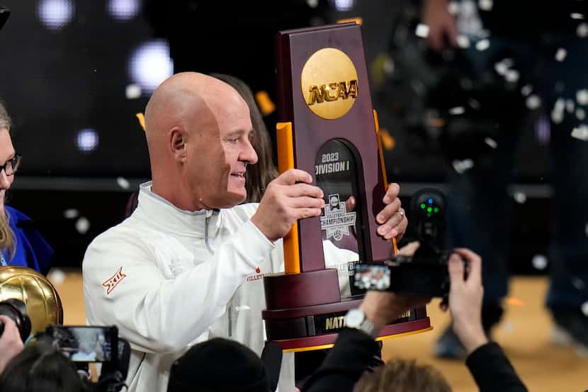Texas head coach Jerritt Elliott holds up the trophy after the team defeated Nebraska during...