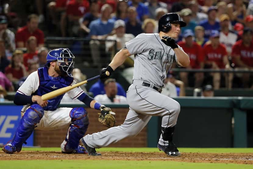 Seattle Mariners' Kyle Seager follows through on a two-run swing as Texas Rangers catcher...