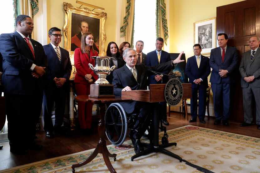 Texas Gov. Greg Abbott, center at podium, lashed out at the Department of Public Safety...
