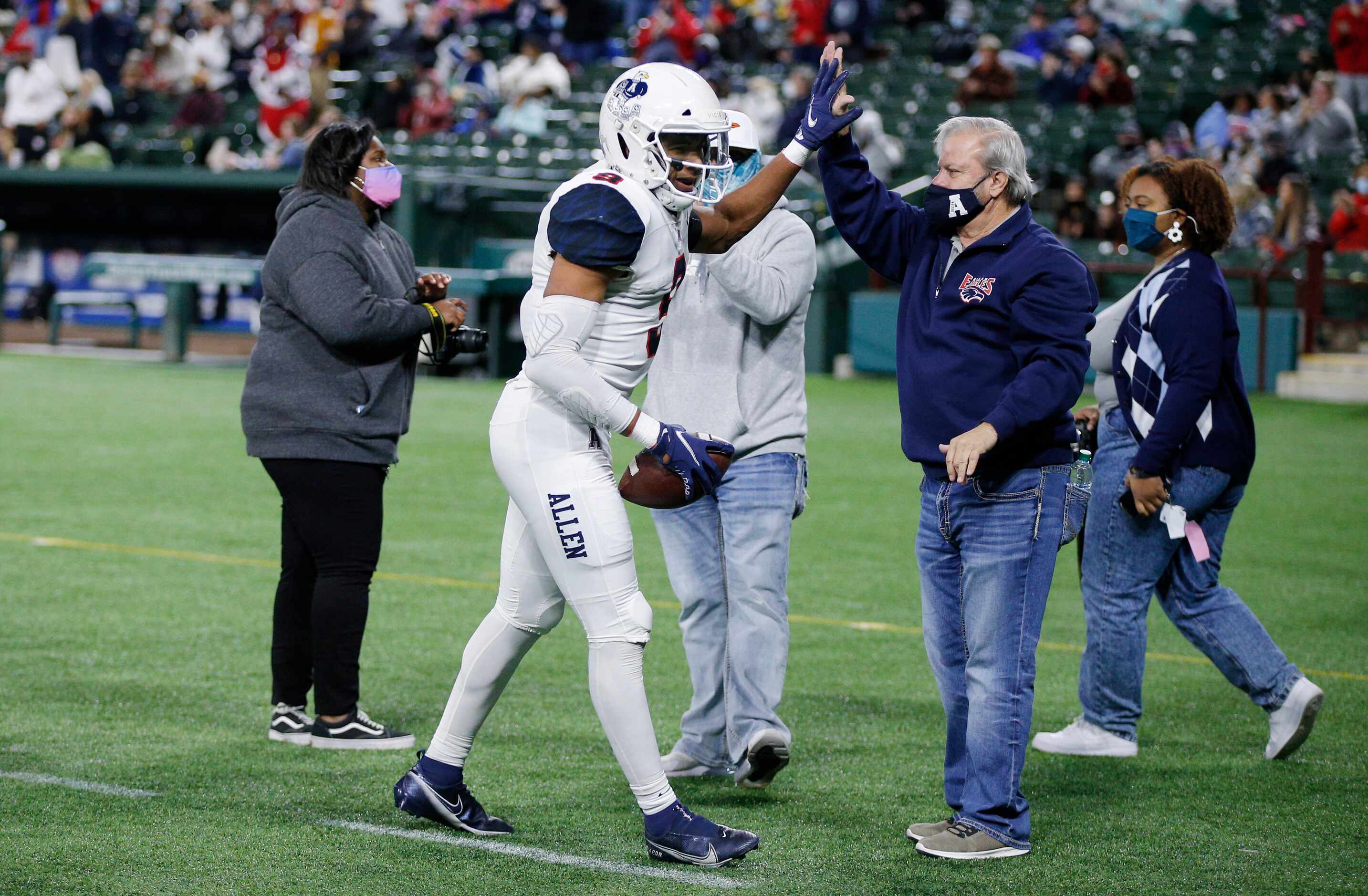 Allen senior wide receiver Bryson Green (9) high fives a fan on the sidelines after scoring...