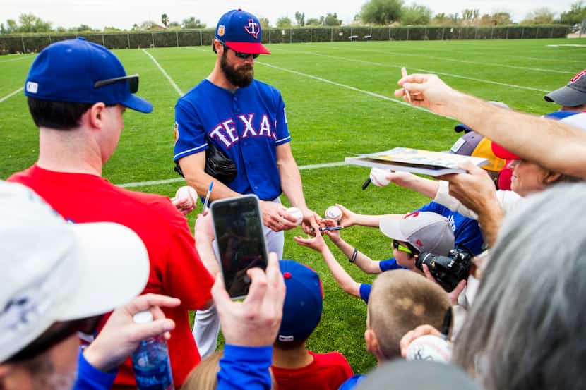 Texas Rangers starting pitcher Cole Hamels (35) signs autographs for fans during a spring...