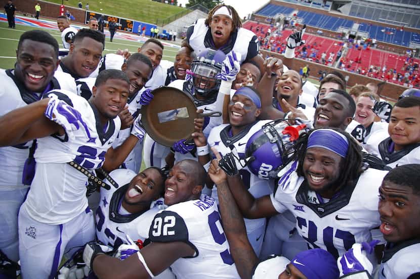 TCU Horned Frogs celebrate with the Iron Skillet trophy after beating SMU 56-0 at Ford...