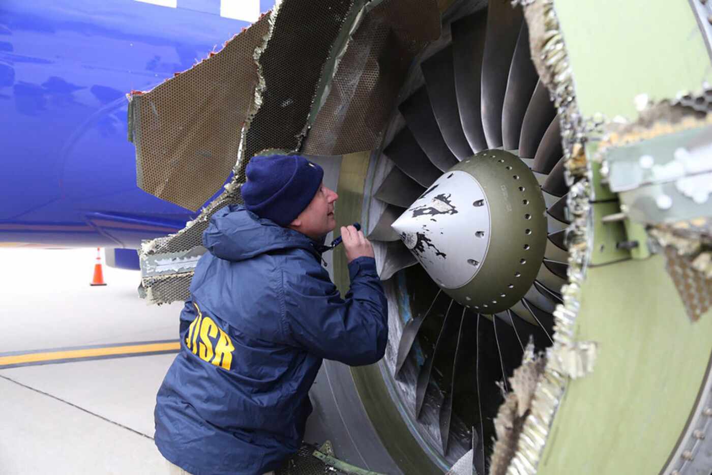 A National Transportation Safety Board investigator examines the Boeing 737 jet engine that...