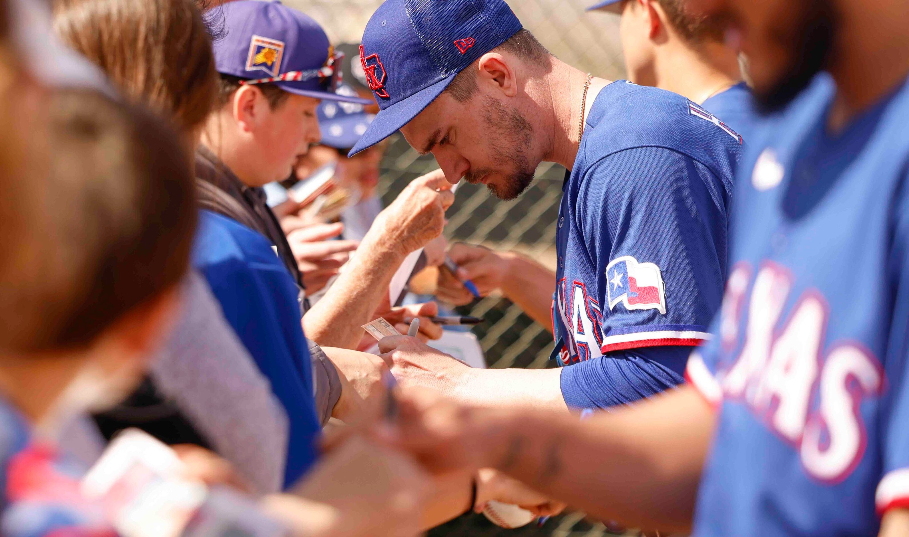 Texas Rangers pitcher Andrew Heaney gives autographs to the attending crowd during a spring...