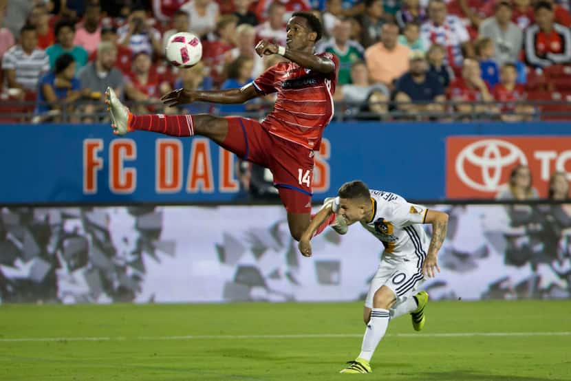 FC Dallas forward Atiba Harris (14) attempted a shot on goal while defended by Los Angeles...