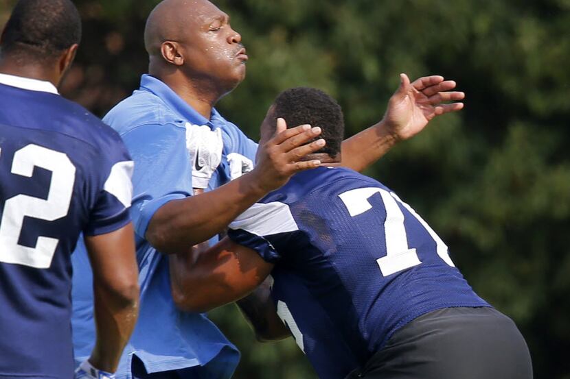 Former Dallas Cowboys player Charles Haley (center) works with defensive end Greg Hardy (76)...