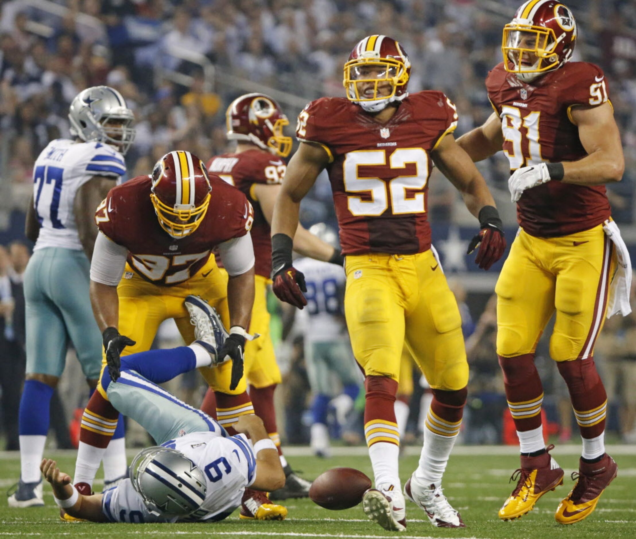 Dallas Cowboys quarterback Tony Romo (9) writhes on the ground after being crunched by...