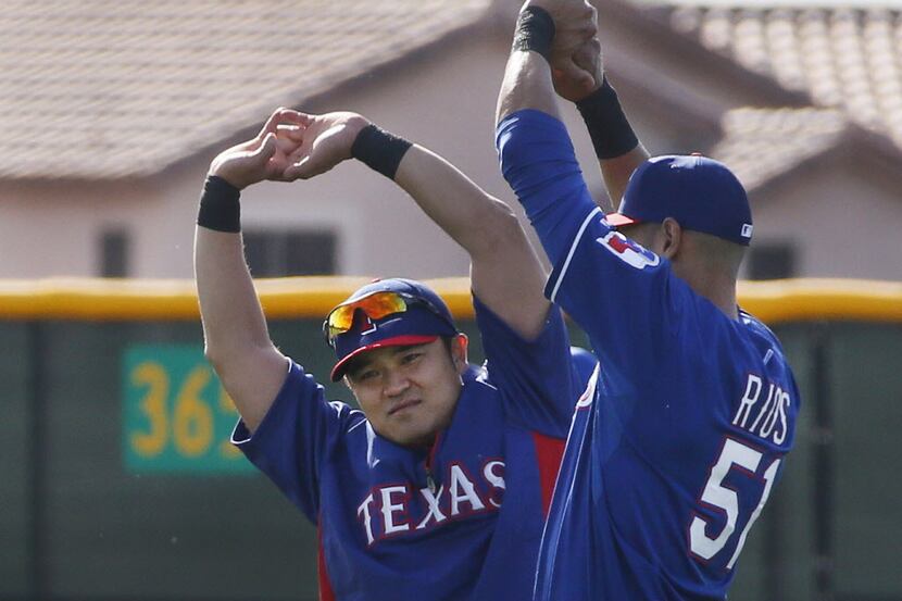 Texas outfielders Shin-Soo Choo, left, and Alex Rios stretch during Texas Rangers baseball...