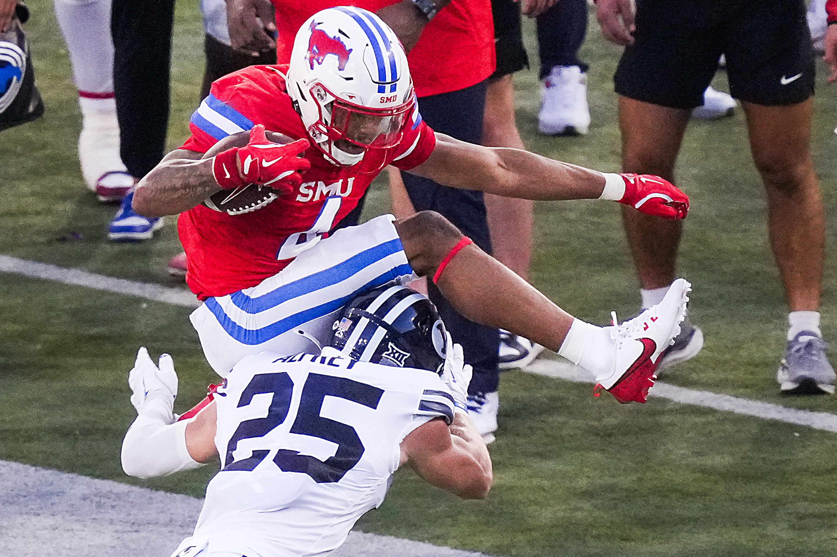 SMU running back Jaylan Knighton (4) tries to hurdle BYU safety Talan Alfrey (25) during the...