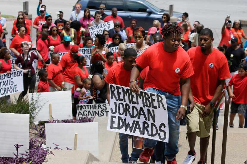 Slain teen Jordan Edwards' brother Vidal Allen, front, leads his family up the steps to the...