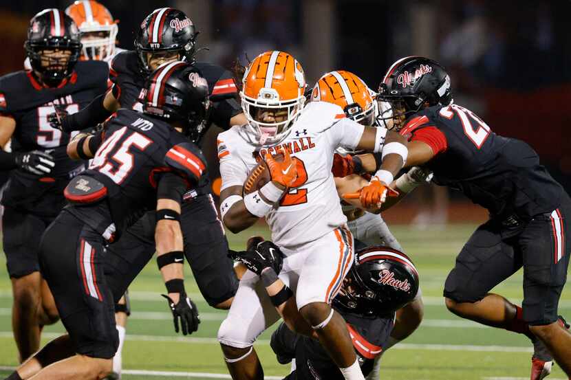 Rockwall's Ashten Emory (2) carries the ball as Rockwall-Heath defense players try to stop...