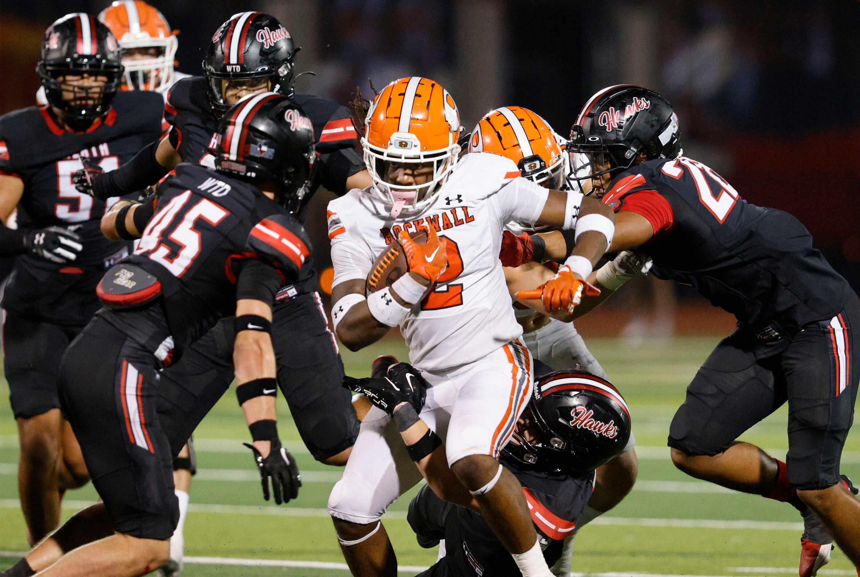 Rockwall's Ashten Emory (2) carries the ball as Rockwall-Heath defense players try to stop...