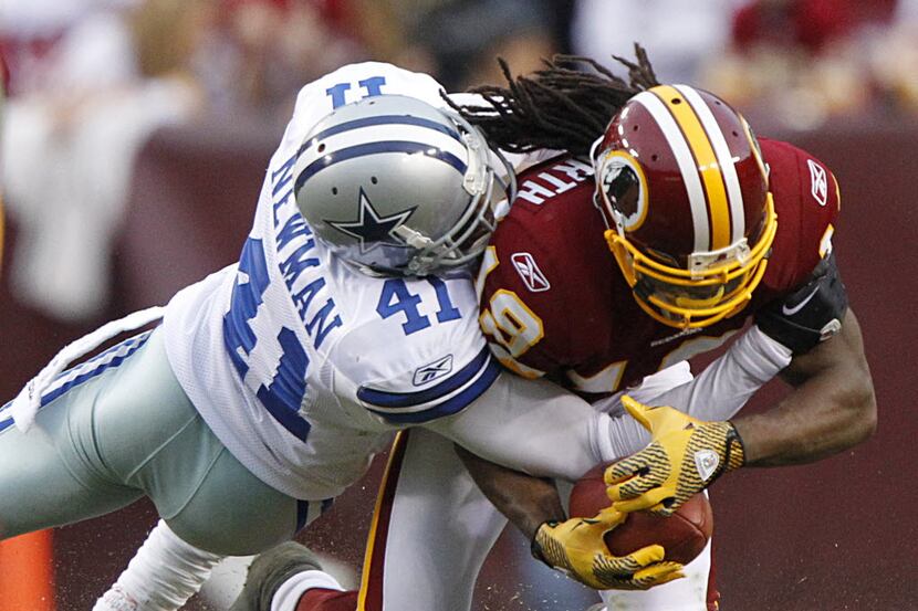 Dallas Cowboys cornerback Terence Newman (41) is bowled over by Washington Redskins wie...