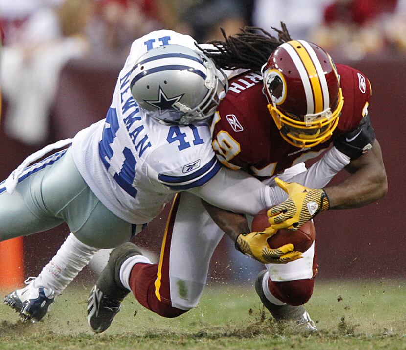 Dallas Cowboys cornerback Terence Newman (41) is bowled over by Washington Redskins wie...