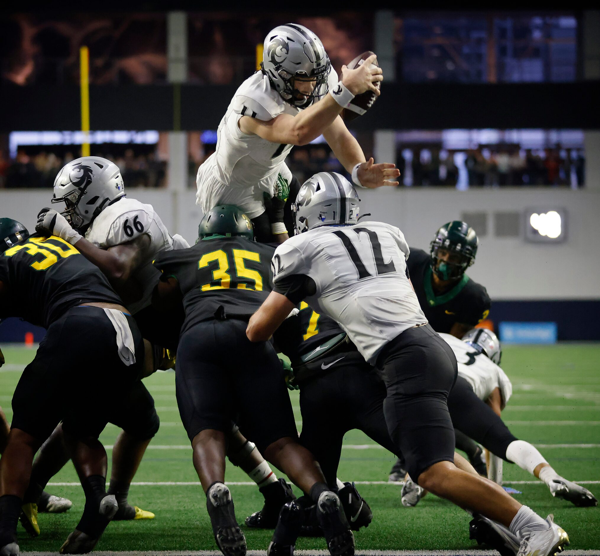 Denton Guyer quarterback Jackson Arnold (11) dives over the DeSoto defensive line for a...