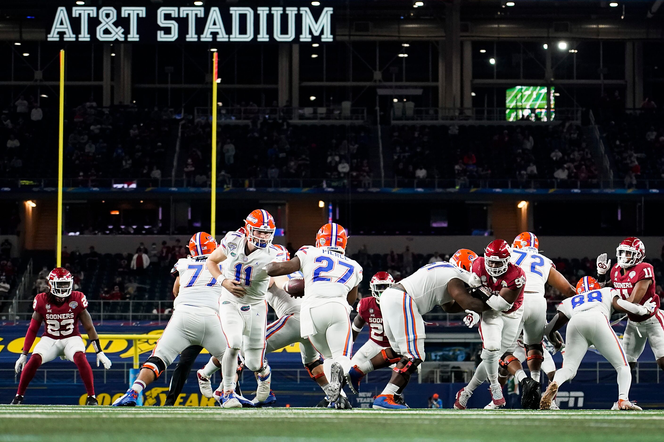 Florida quarterback Kyle Trask (11) hands the ball off to running back Dameon Pierce (27)...