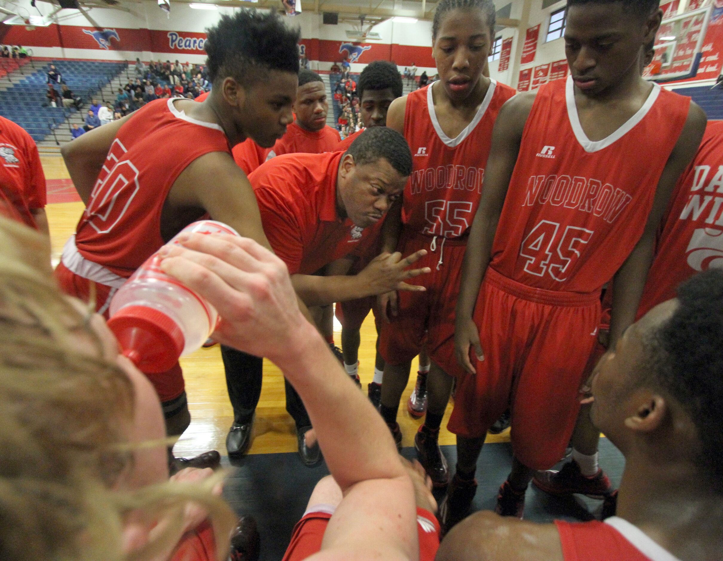 Woodrow Wilson head coach Patrick Washington makes a point with his players in a huddle on...