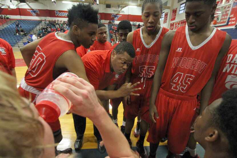 Woodrow Wilson coach Patrick Washington talks to his players during a playoff game against...