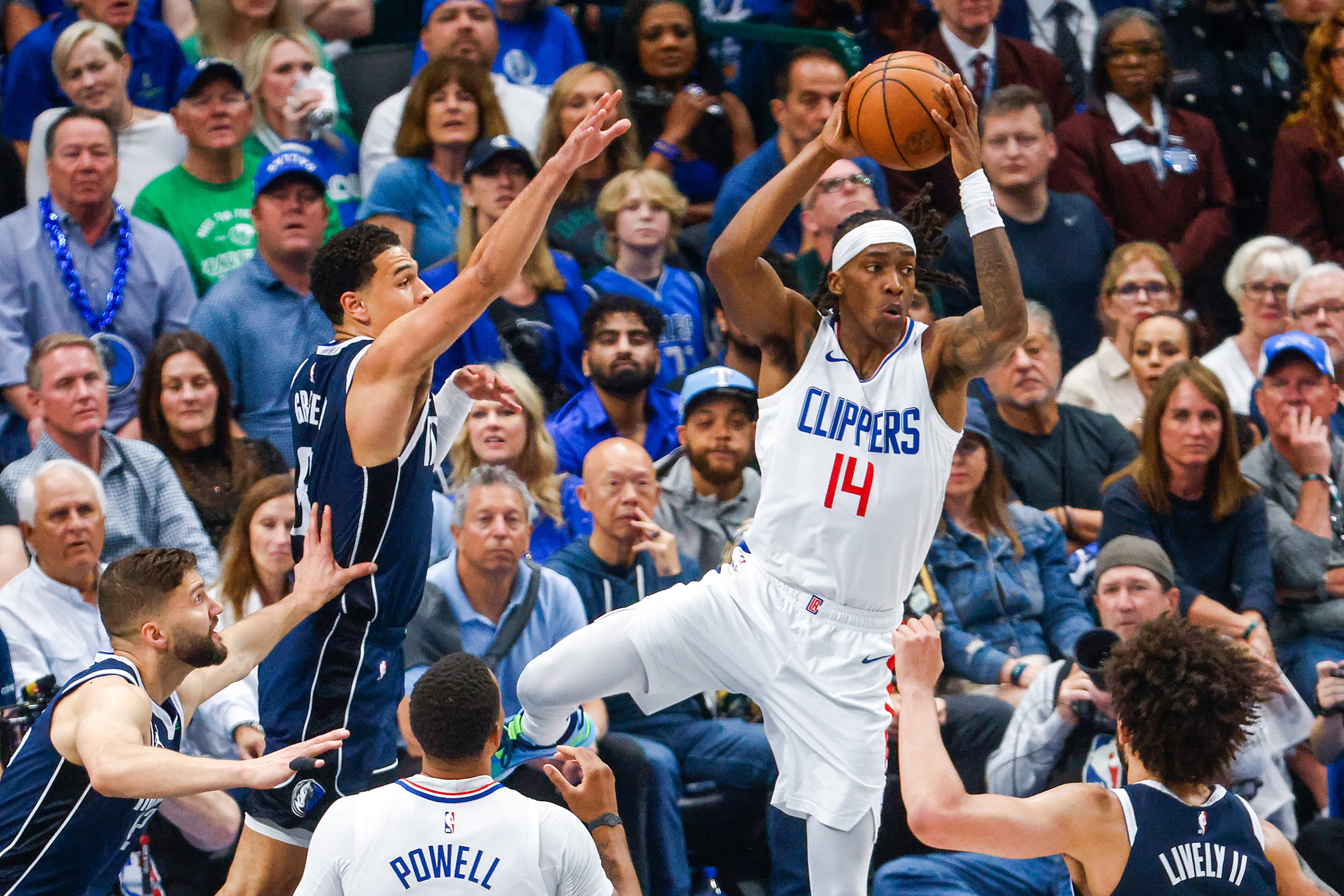 LA Clippers guard Terance Mann (14) looks to pass past Dallas Mavericks guard Josh Green...