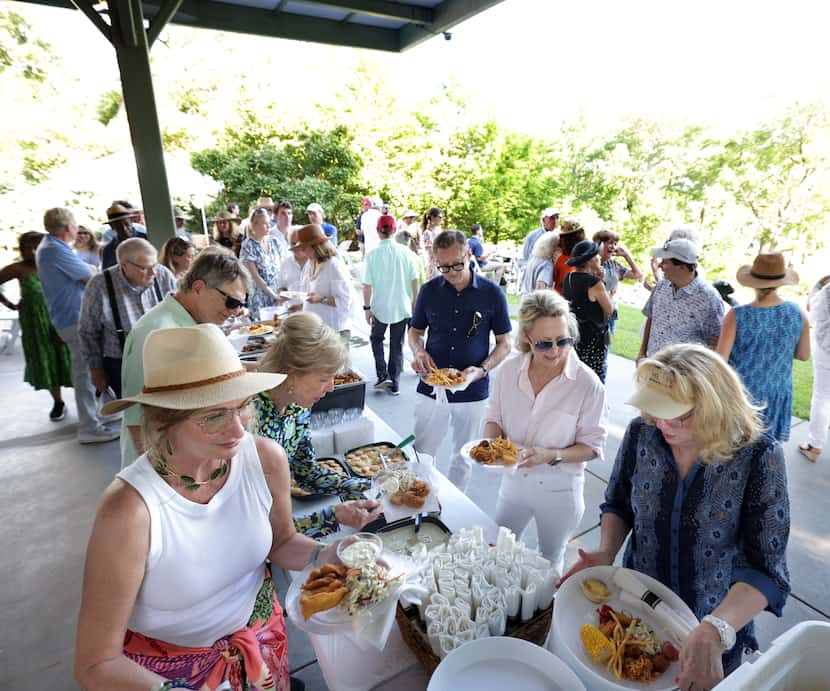 Guests eat crawfish, fried catfish, hush puppies, and more at a buffet feast on Shannon...