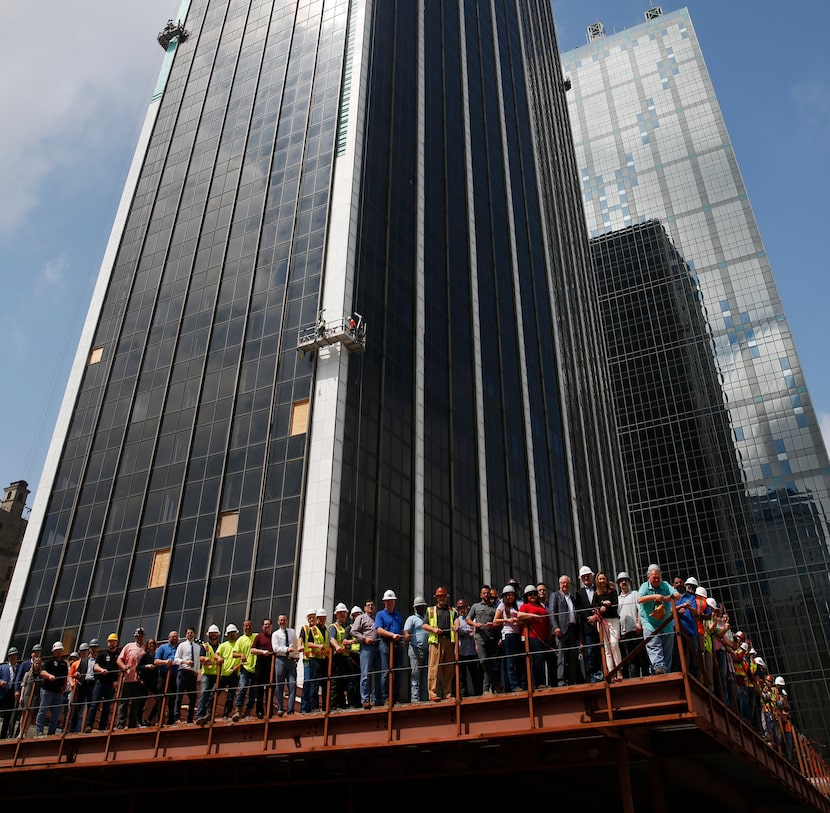 Construction workers pose for a photograph as renovation restarts at First National Bank...