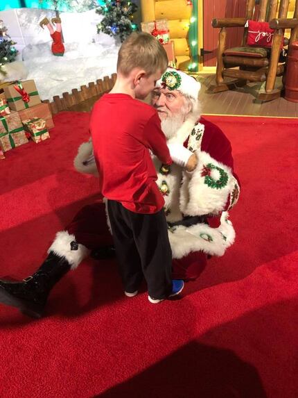 Matthew Foster, 6, feels Santa James Langley's coat and beard during a recent visit at...