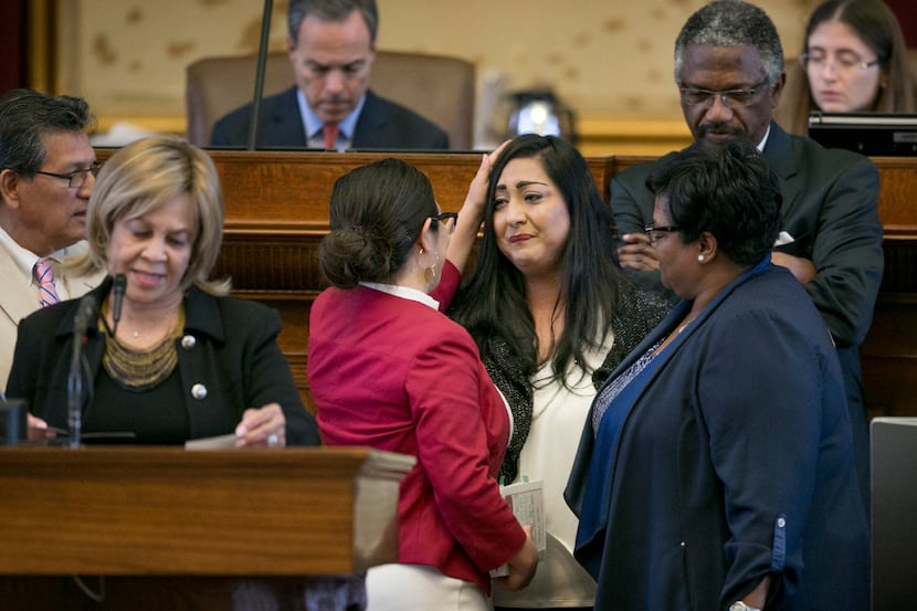 State Rep. Mary Gonzalez, D-Socorro, left, back to camera, consoles state Rep. Diana...