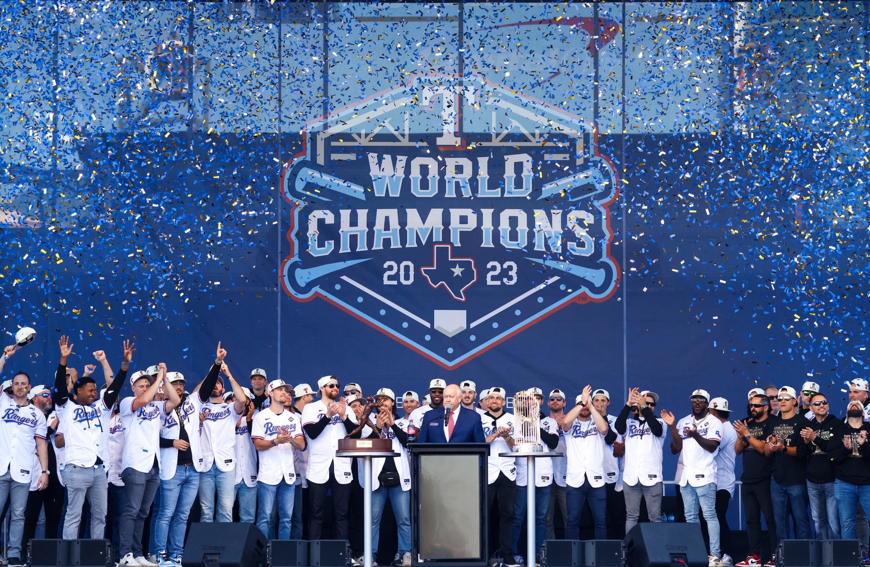 Confetti flies during the last half of Texas Rangers post-parade public celebration lead by...