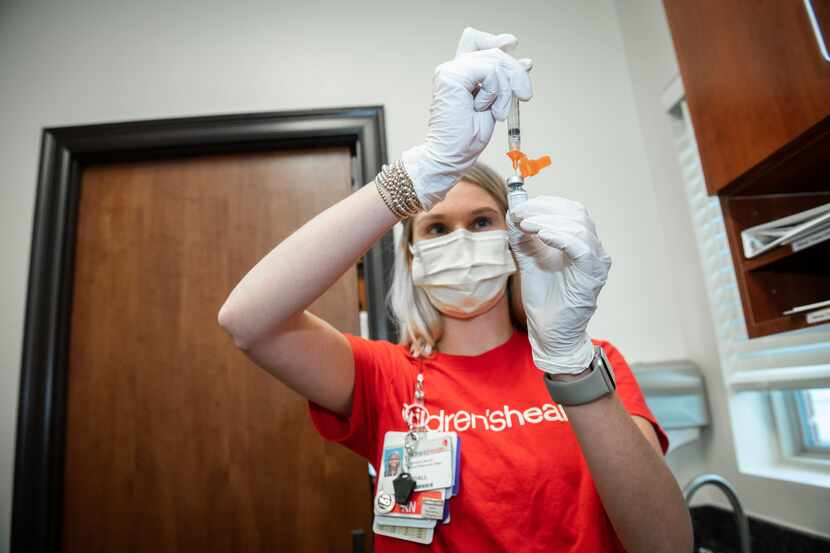 A COVID-19 vaccination is prepared at Children's Health by nurse Kendall Frenkel.