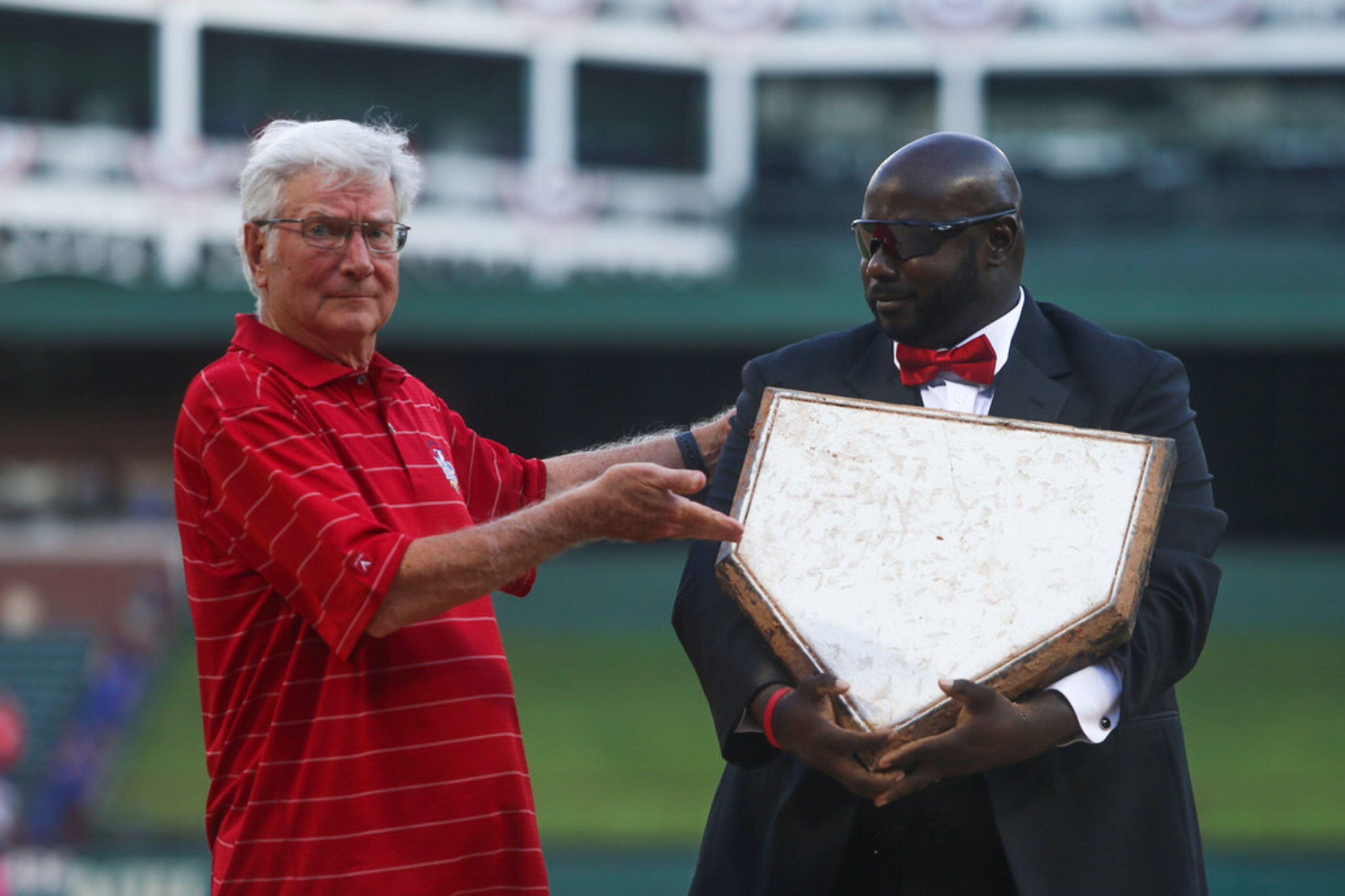 Former Mayor of Arlington Richard Greene hands off the home plate to groundskeeper Devo...