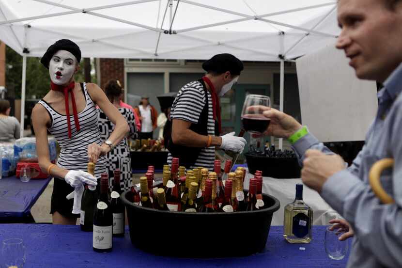 Robyn Pinilla, left, and David Pinilla, center, serve wine to Jeff Chesnut, right, during...