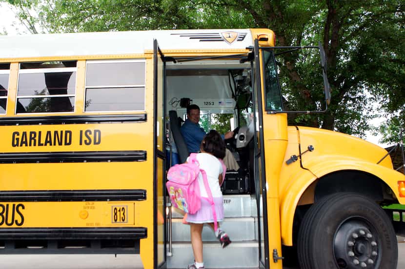 Garland ISD bus driver Parker Abell (left) greets Rosa Medrano as she boards the bus for...