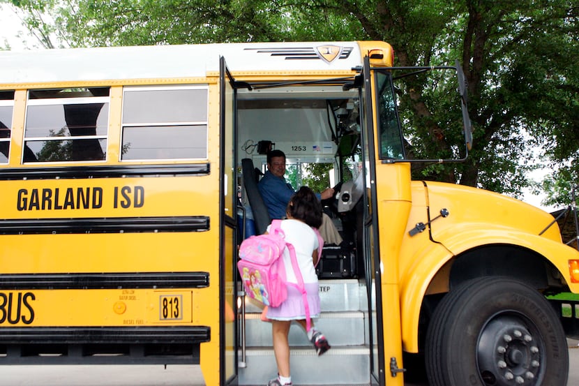 Garland Independent School District bus driver Parker Abell (left) greets Rosa Medrano as...