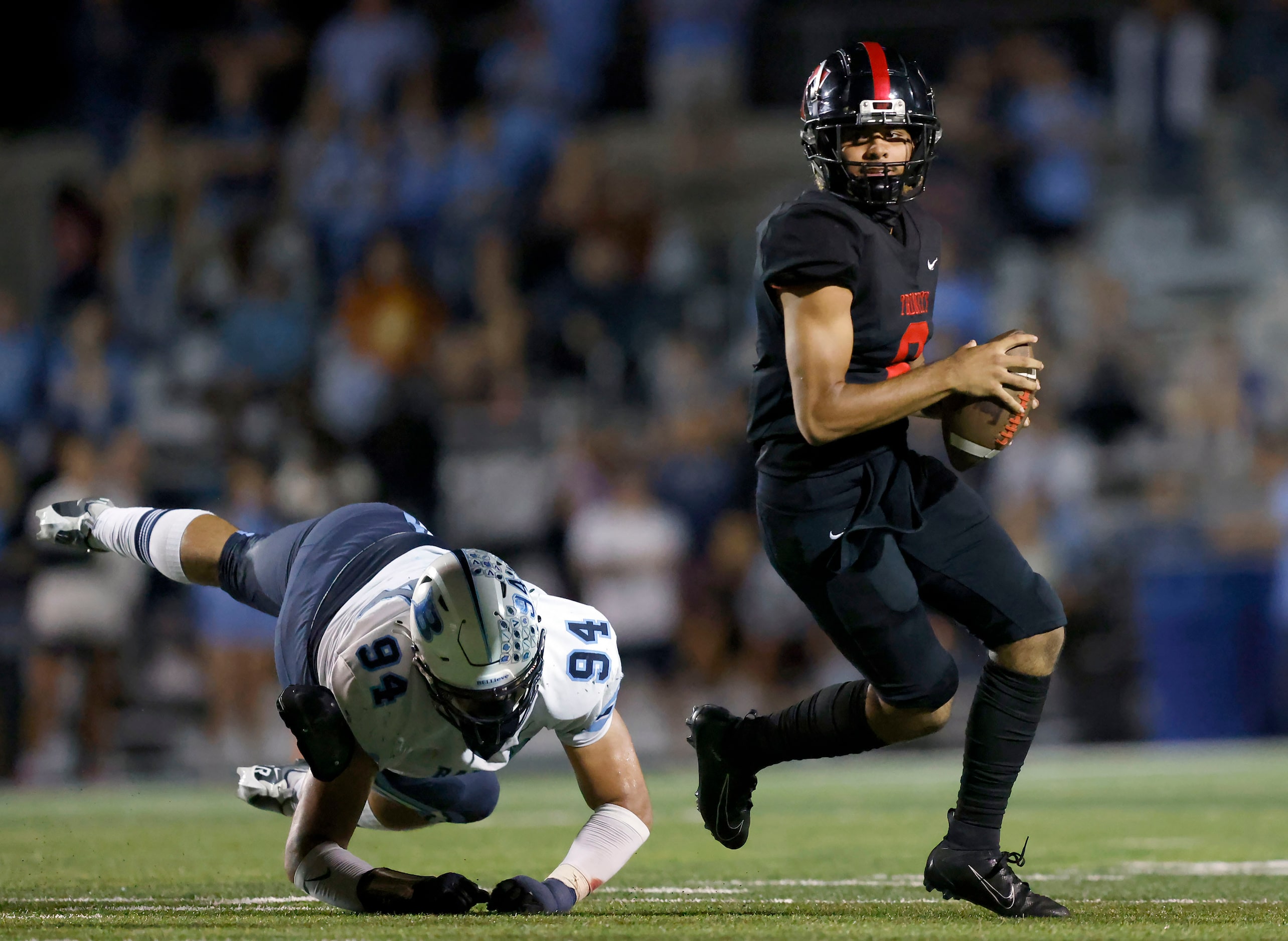 Euless Trinity quarterback TJ Topou (8) escapes from Hurst L.D. Bell lineman Kyland Brown...