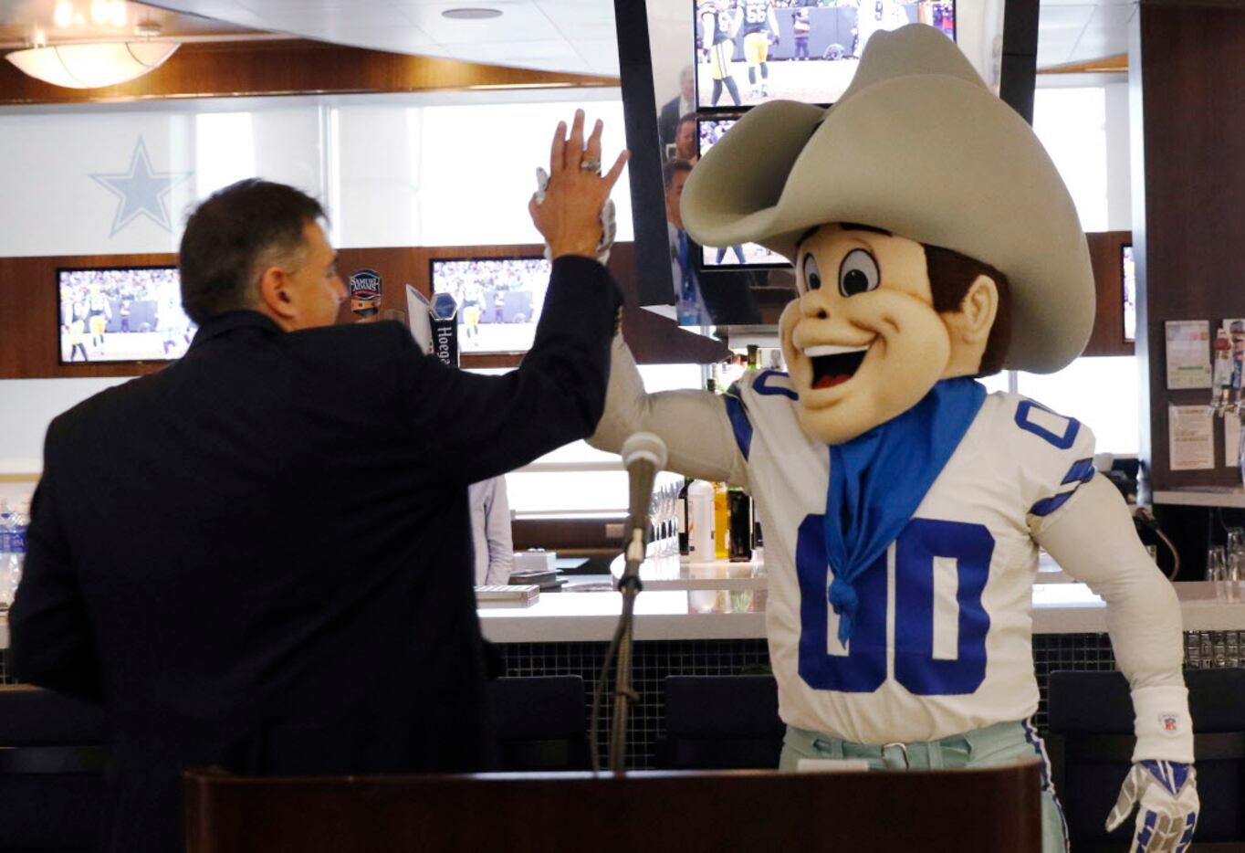 David Magana, who manages corporate communicates for D/FW Airport, gives a high-five to...