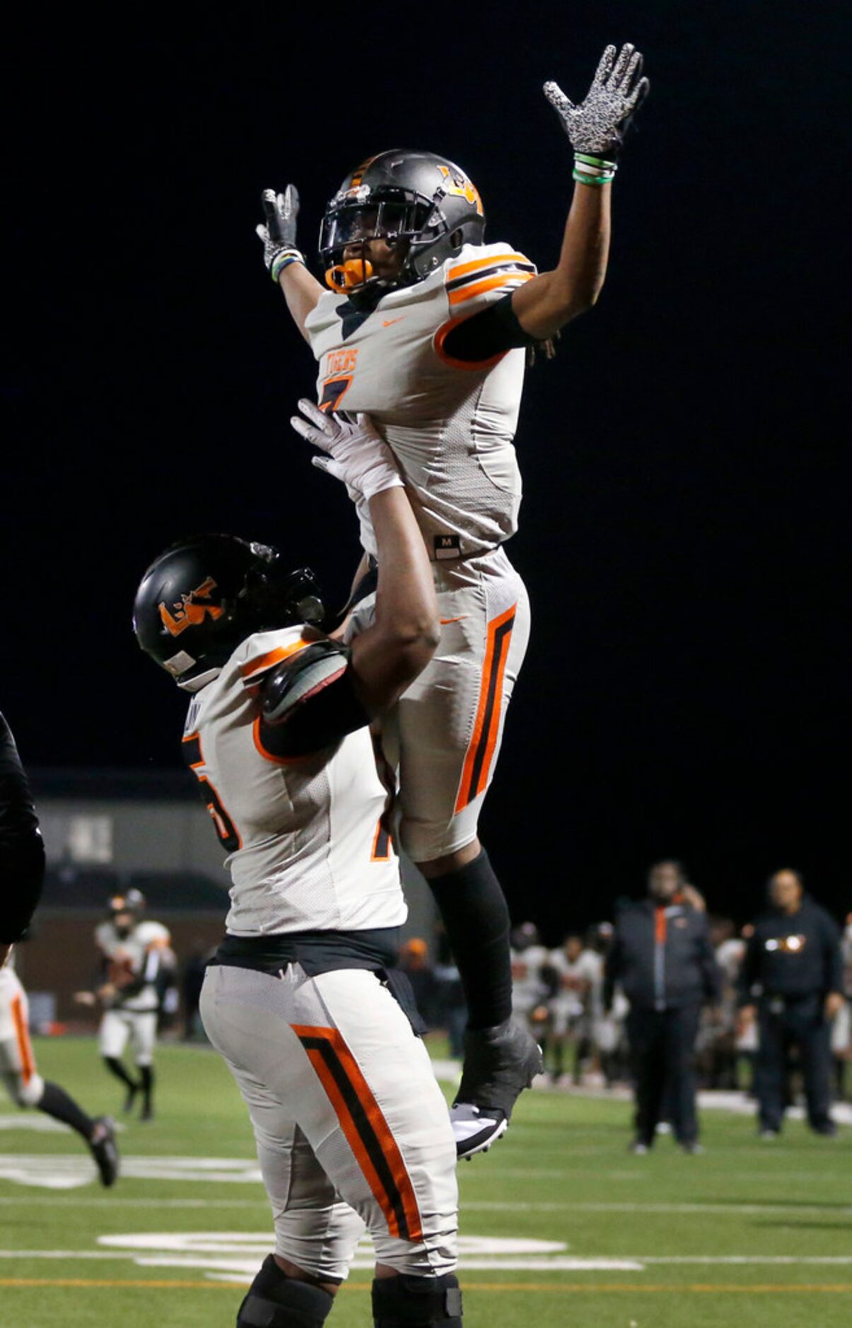 Lancaster running back Karon Neblett (7) is hoisted in the air by teammate Isaiah Sillemon...