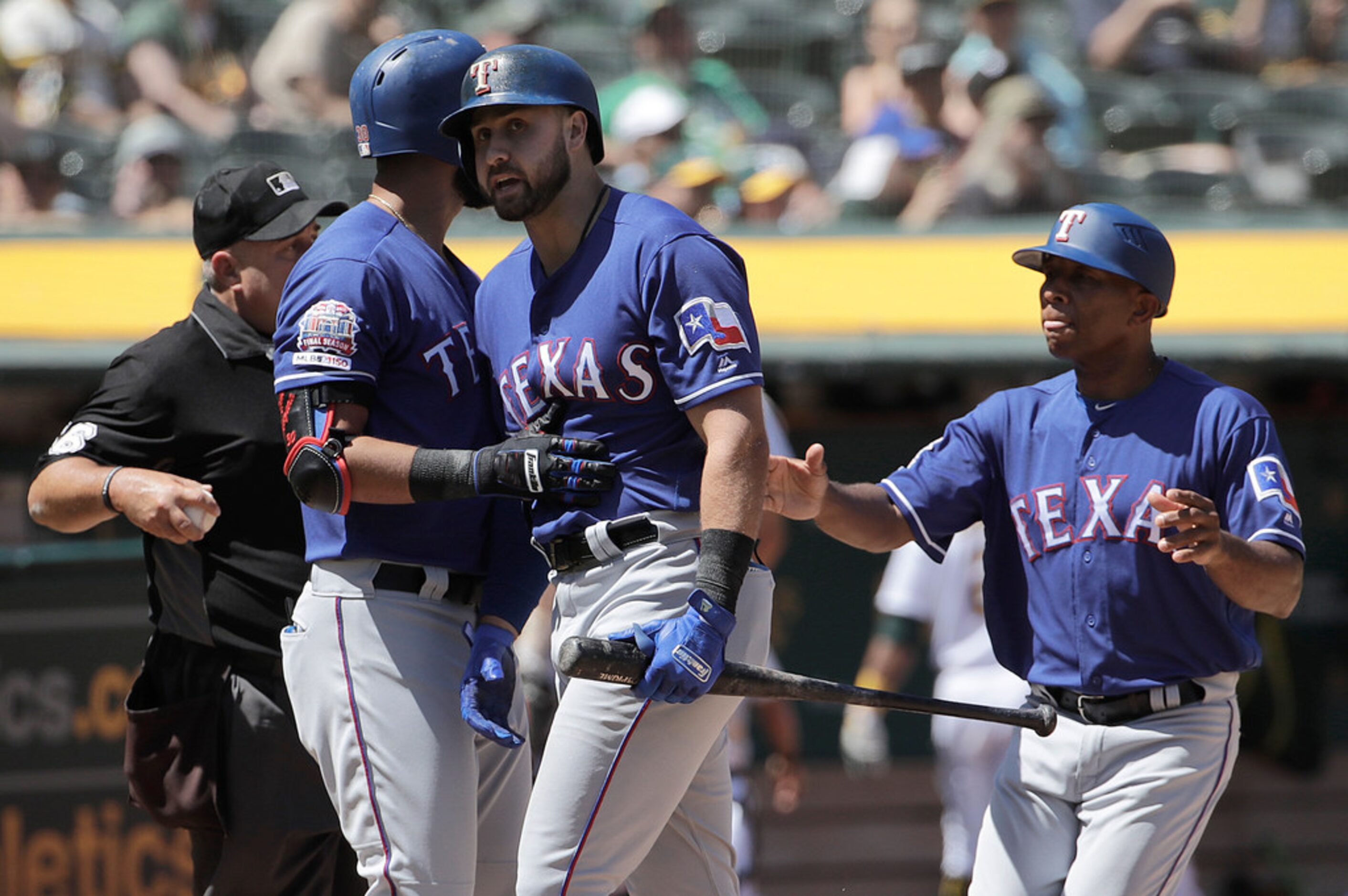 Texas Rangers' Joey Gallo, center, is held back by Nomar Mazara, second left, while arguing...