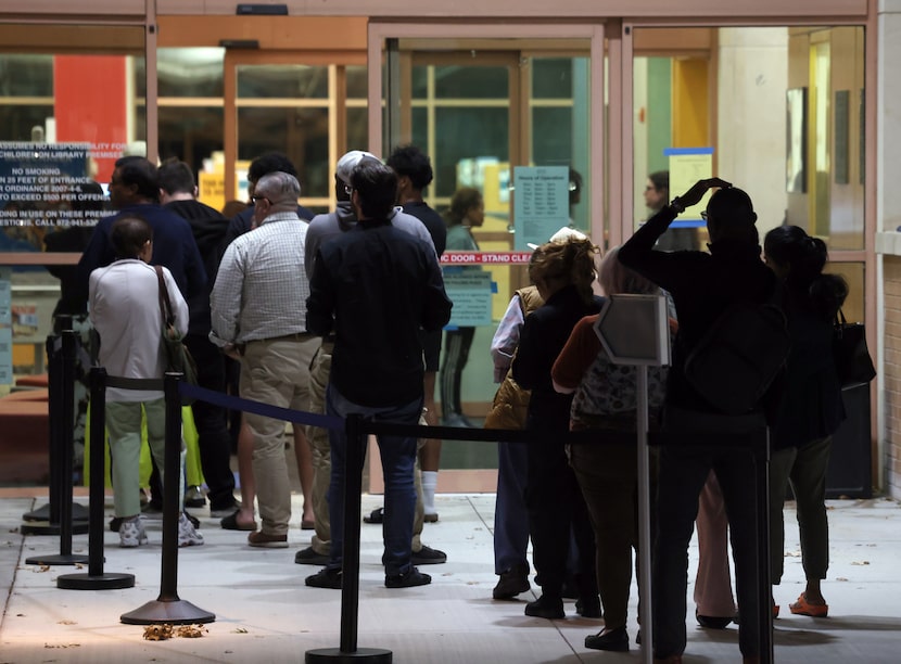 Voters wait in a line during the final hour of polls open at the Haggard Library in Plano....