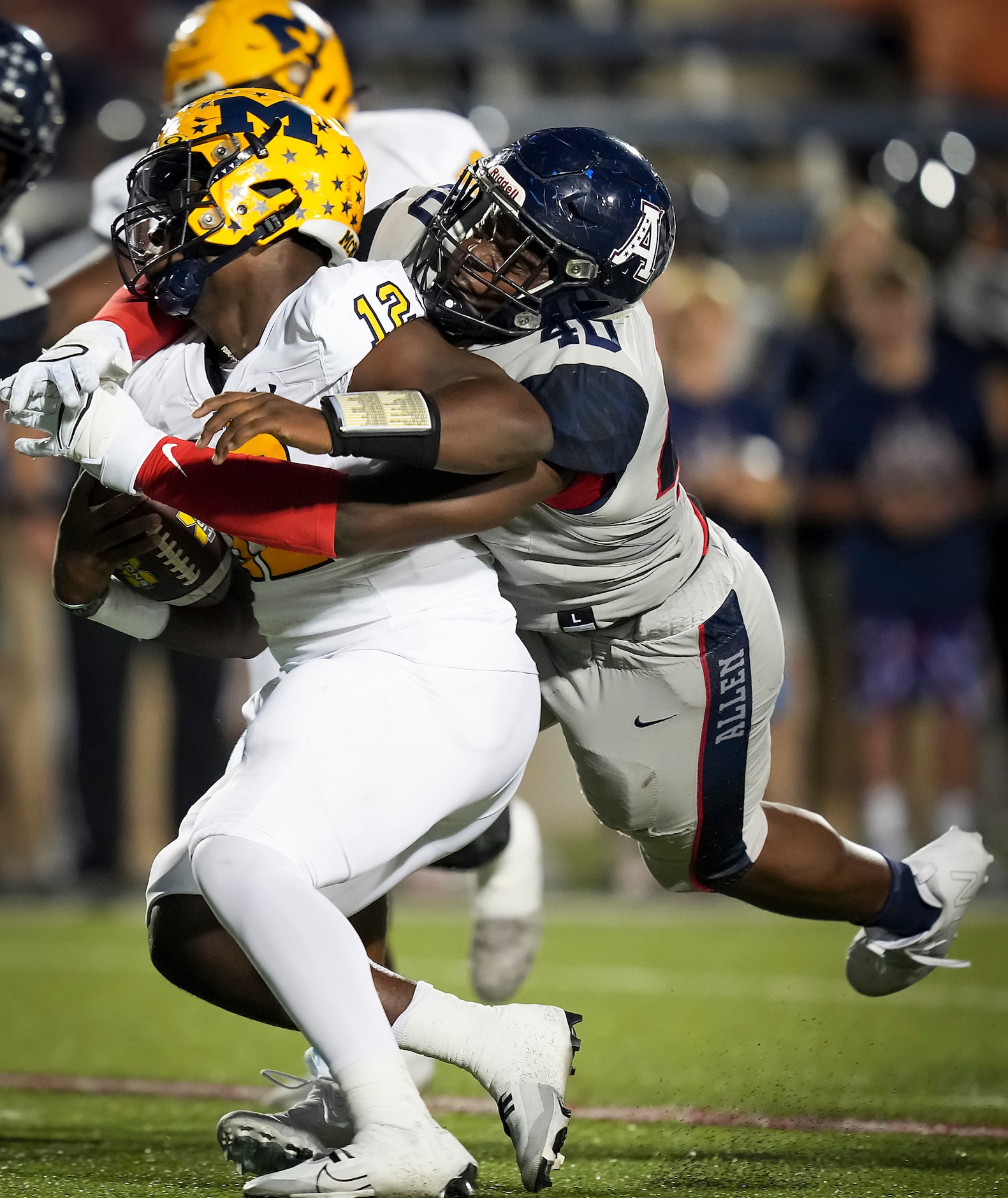 McKinney quarterback Keldric Luster (12) is sacked by Allen defensive lineman Nathan Marsh...