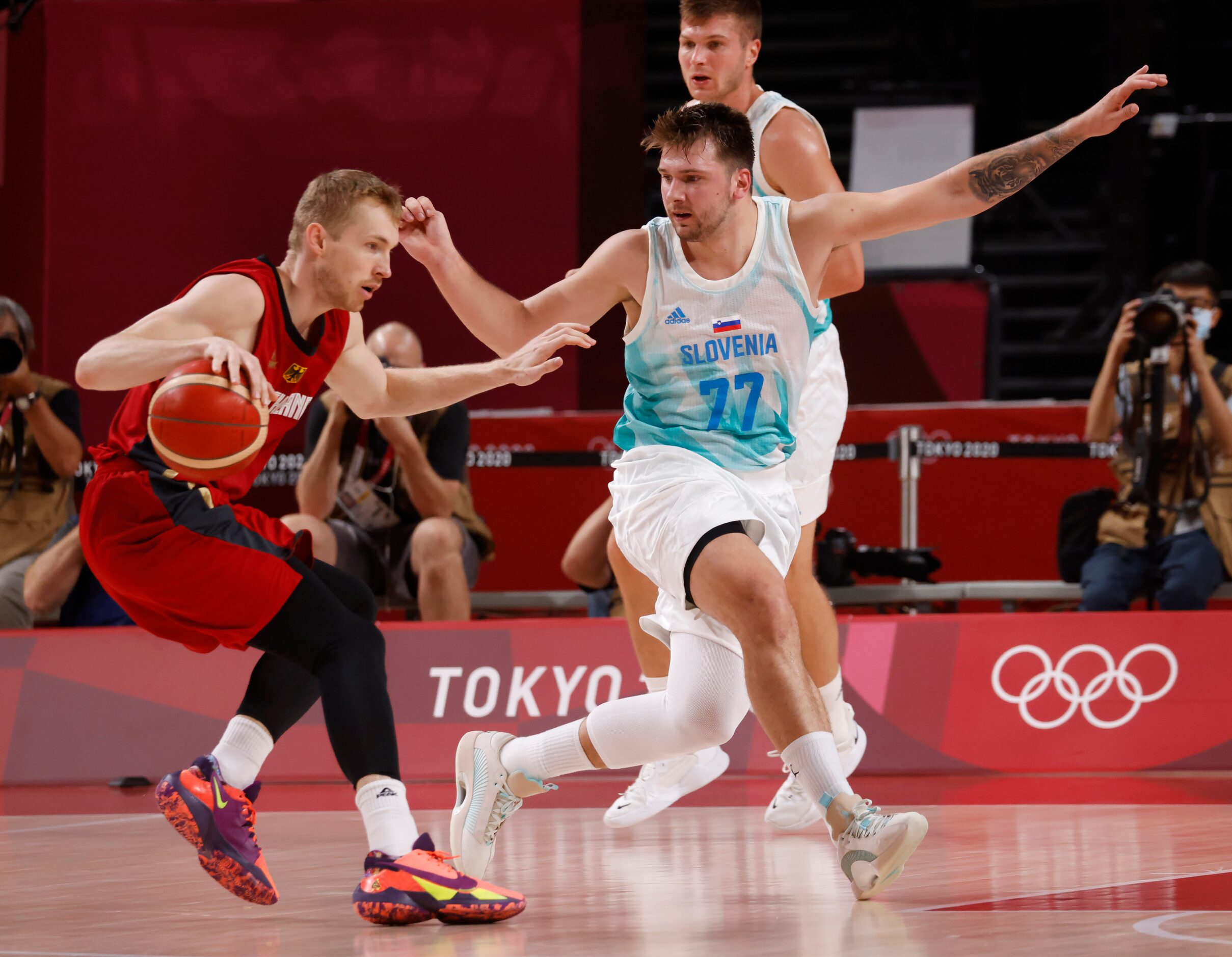 Slovenia’s Luka Doncic (77) defends as Germany’s Niels Giffey (5) dribbles during the first...