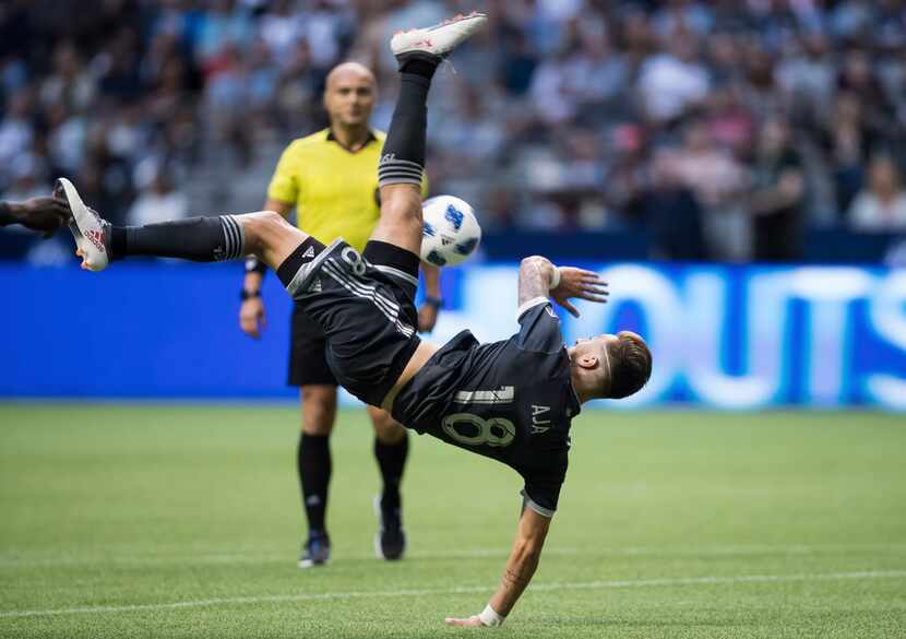 Vancouver Whitecaps' Jose Aja stumbles as he attempts a shot on goal against the Chicago...