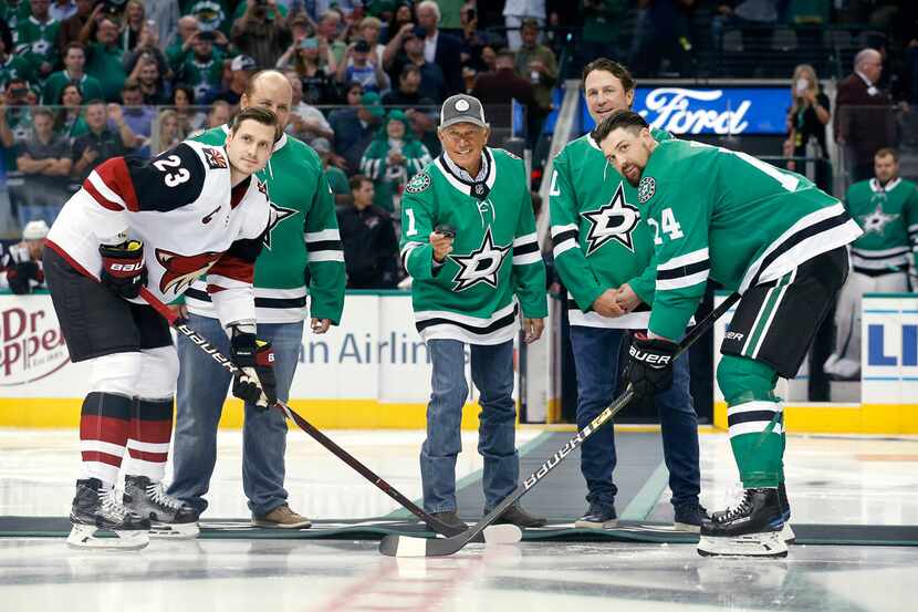 Country singer George Straight (center) drops the ceremonial puck before the Dallas Stars...