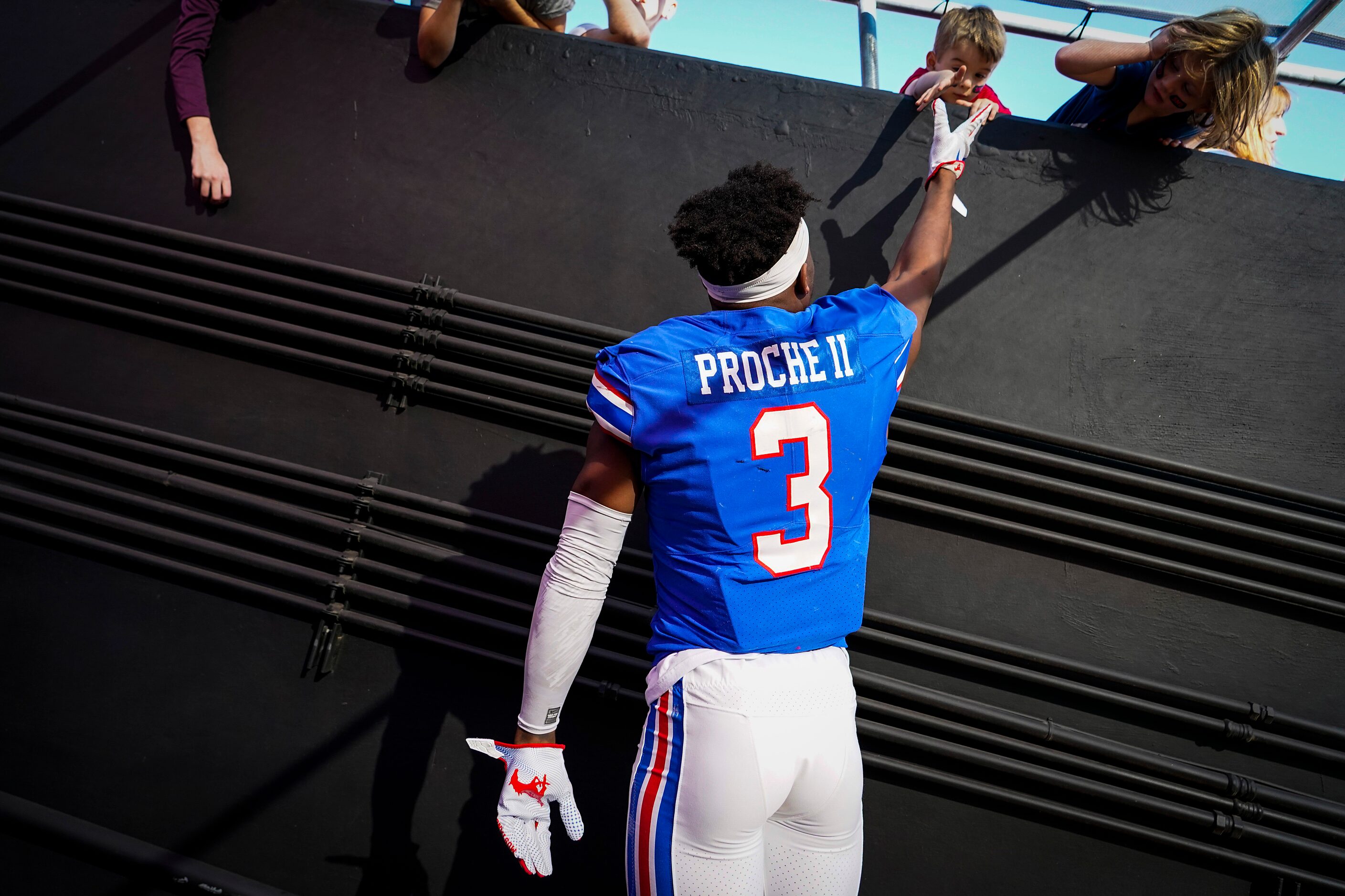 SMU wide receiver James Proche jumps to high five a young fan before an NCAA football game...