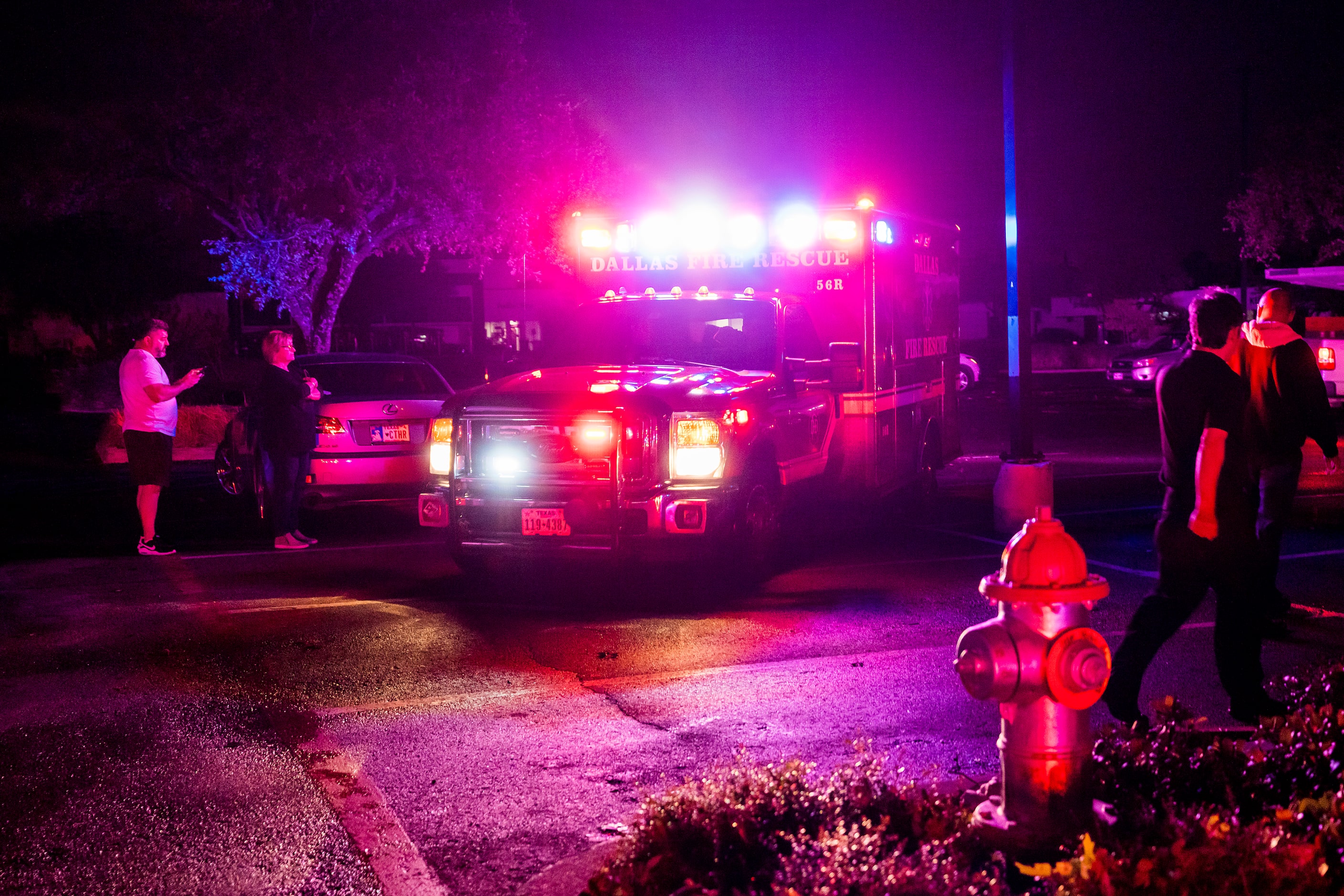 A Dallas Fire Rescue Ambulance moves through a shopping center parking lot after a tornado...